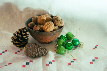 Walnuts in a bowl, cones and Christmas decorations