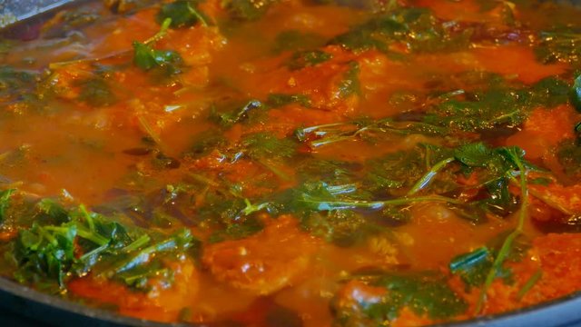 Traditional Moroccan Fish dish in a cooking pot with hot tomatoes sauce and oriental herbs
