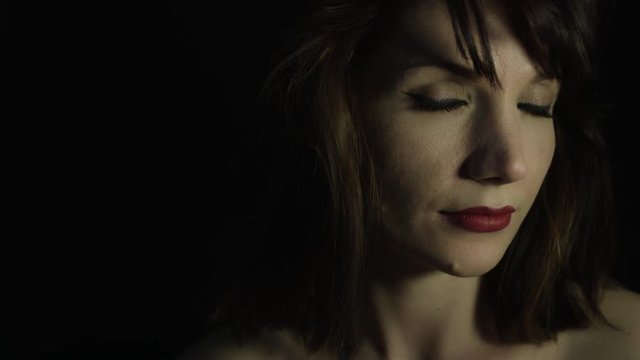 4k shoot of a woman in studio thinking and smiling at camera