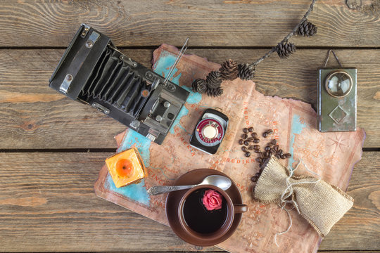 Card, cup of coffee and vintage camera on wooden table