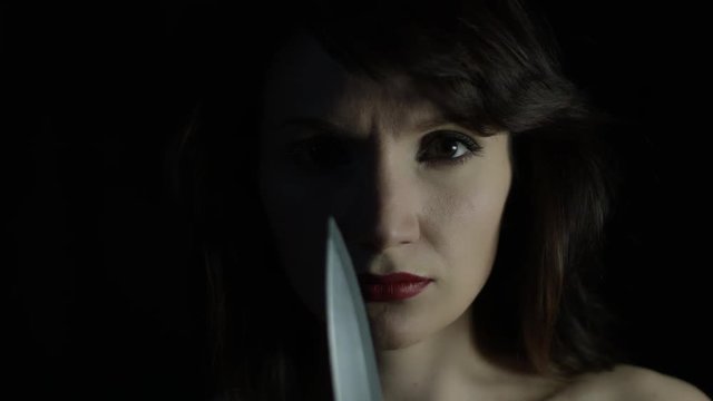 4k shoot of a woman in studio with a knife