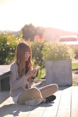 Obraz premium Happy woman smiling and using a smartphone