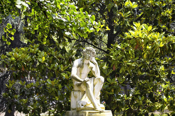 View of a thinking man sculpture with trees in the background at Jardin Du Luxembourg.