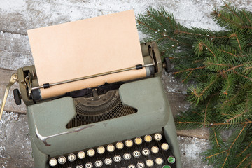 Christmas concept - workplace with a typewriter and spruce branches on a wooden table
