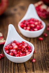 Pomegranate seeds on wooden background (selective focus)