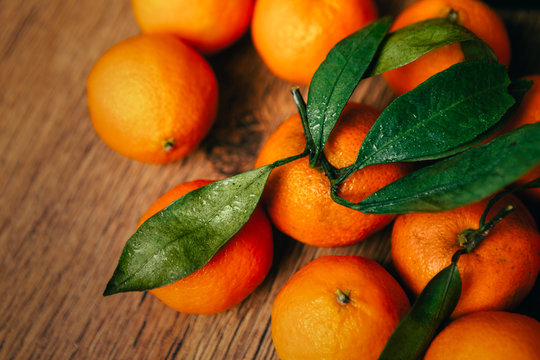 many fresh tangerines on a wooden background