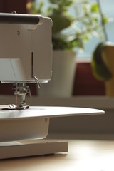 Nähmaschine zu Hause auf Tisch vor Fenster, Rückansicht Detail