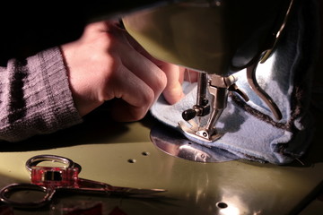 Nähen Stiefel an grüner Nähmaschine, Vordergrund mit Schere und Klammern