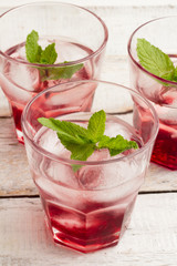 glasses with red drink and ice and mint