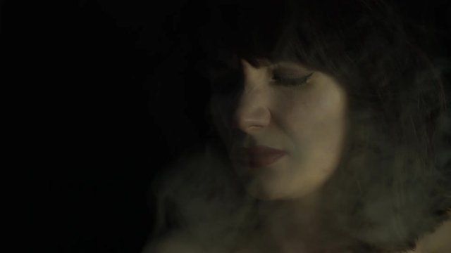 4k shoot of a woman in studio exposed to smoke