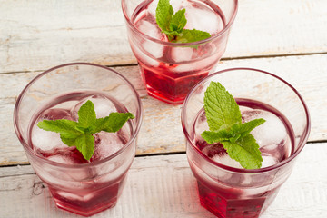 red cocktail with ice and mint in a glass view from above