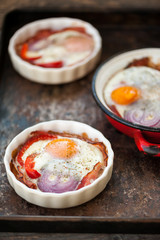 Baked eggs with bacon, red pepper  and onion