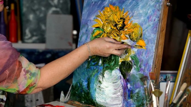 Process of oil painting, artist paints picture on canvas. Sunflowers.