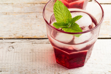 red juice with mint and ice in a glass closeup