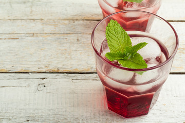 red drink with mint and ice in a glass closeup