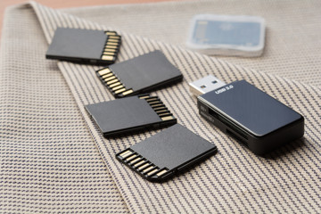 Black memory cards and card reader on textile background