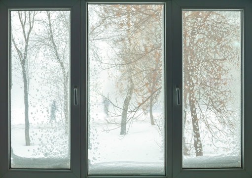 window in russian flat with snow blizzard and trees
