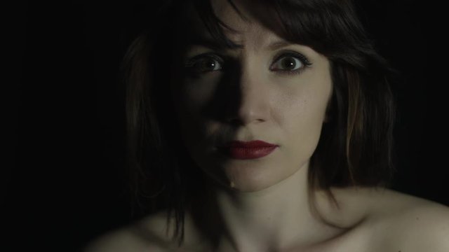 4k shoot of a woman in studio with a hand on her mouth