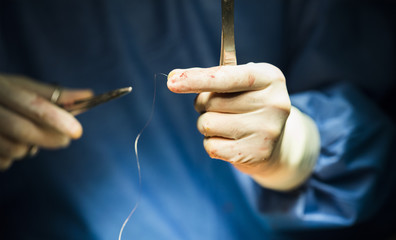 Surgeon holding a needle and thread