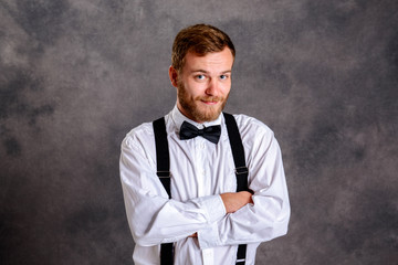 Fototapeta premium bearded man in white shirt and bow tie in front of gray backgro