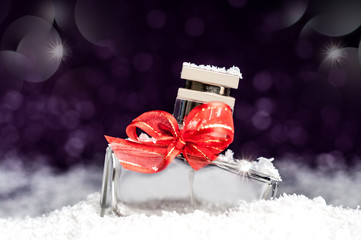 perfume bottle in the snow on a purple background © Yalana