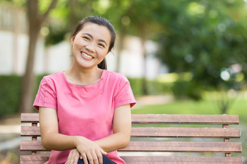 Happy woman sittng on the bench at park