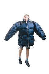 Fototapeta premium Funny excited child wearing colorful down jacket jumping in excitement. Winter clothes and vacation concept. Isolated on white background.