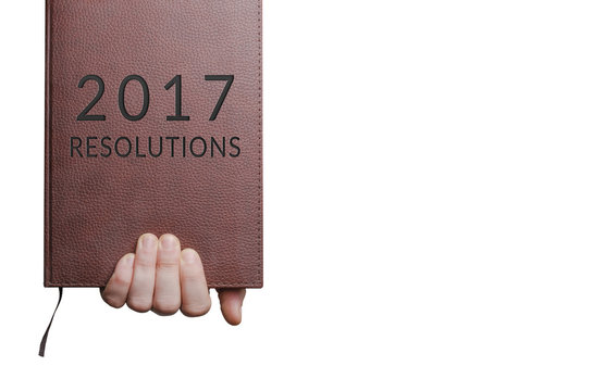 2017 resolutions book in hand isolated on white background