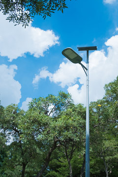 Led spotlight with solar power in street garden and blue sky background.