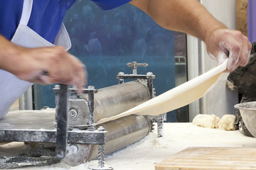 Men hands roll out dough close up.