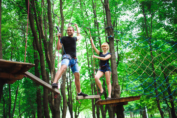 Naklejka na ściany i meble Hiking in the rope park two young people