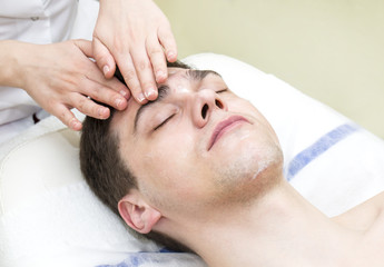 Fototapeta na wymiar Man in the mask cosmetic procedure in spa salon