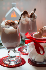 Hot chocolate drink with milk and marshmallow in glass mug.