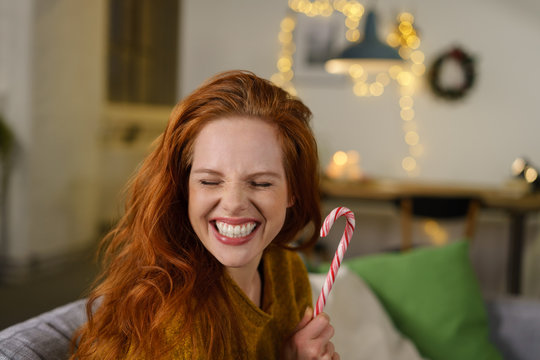 gl&uuml;ckliche frau mit zuckerstange in der adventszeit