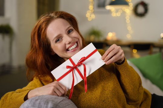 attraktive frau freut sich &uuml;ber einen gutschein zu weihnachten