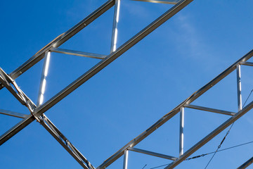 Two metal trusses against blue sky