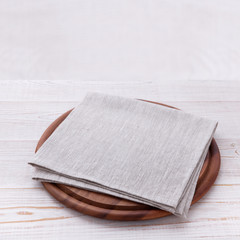Napkin on table in perspective. Napkin close up top view mock up for design. Frame of round cutting board and white tablecloth. Place for text