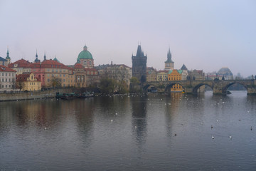 Fototapeta premium Prague, Czechia - November, 21, 2016: morning fog on Vltava river in Prague, Czechia. There is Charles Bridge in the background.