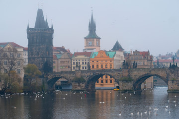 Prague, Czechia - November, 21, 2016: morning fog on Vltava river in Prague, Czechia. There is Charles Bridge in the background.