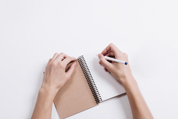 Close-up of female hands writing in Notepad with a pen on a tabl