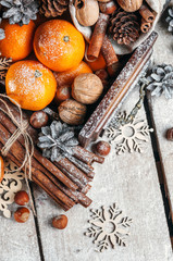Christmas composition, Tangerines, pine Cones, Snowflakes ,decor, Bunch of Cinnamon, Walnut.Brown Wooden Background.The view from the top.