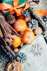 Composition of Christmas gifts,Fir branches,Tangerines, pine Cones,dried oranges, nuts,ornaments and decorations.Festive Boxes With Gifts, cinnamon Sticks.