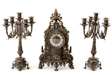 Two vintage bronze candle holder and clock on a white background