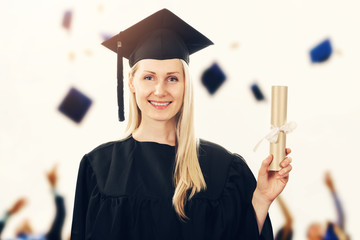 college graduation - woman wearing gown showing diploma