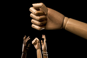 Hands manifest under a large closed fist.  About racism. Isolated on black background. With copy...
