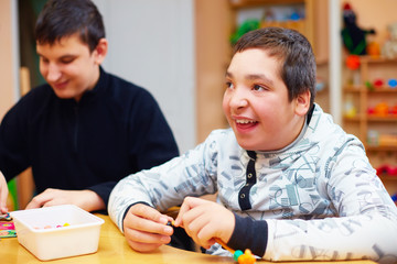 happy kids with disability develop their fine motor skills at rehabilitation center for kids with...