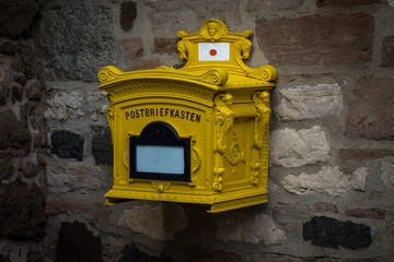 The old, iron mailbox on a stone wall.