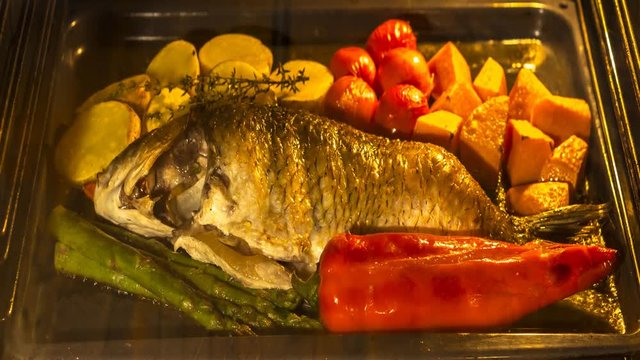 Cooking fish and vegetables in baking oven , time lapse
