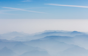 aerial view of layers of mountains covered with clouds
