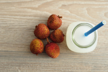 Litchi juice in a glass bottle with a blue straw 